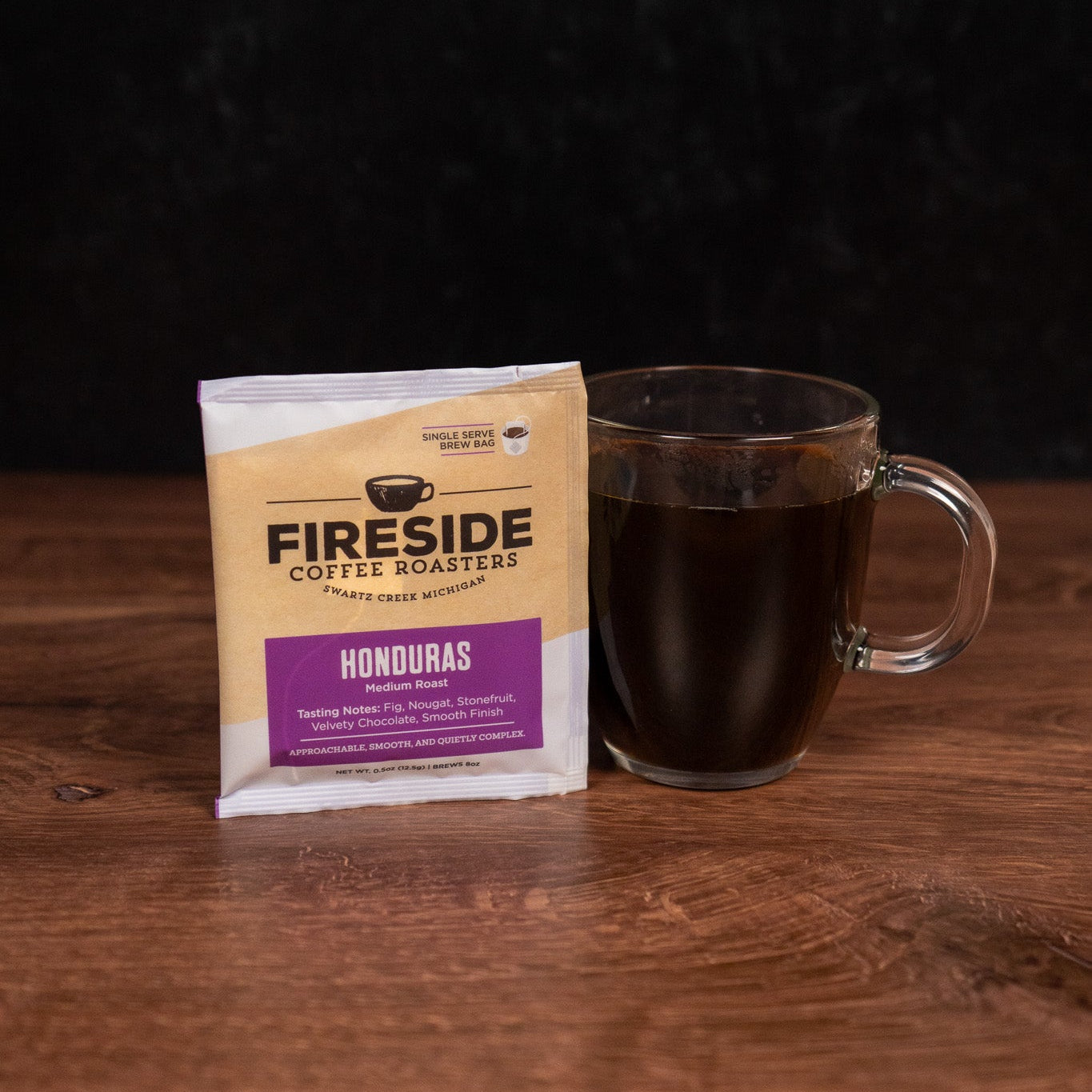 Fireside Coffee package with a glass mug of coffee on a wooden surface