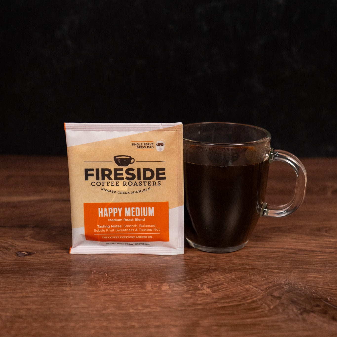 Fireside Coffee Roasters package with a glass of coffee on a wooden surface