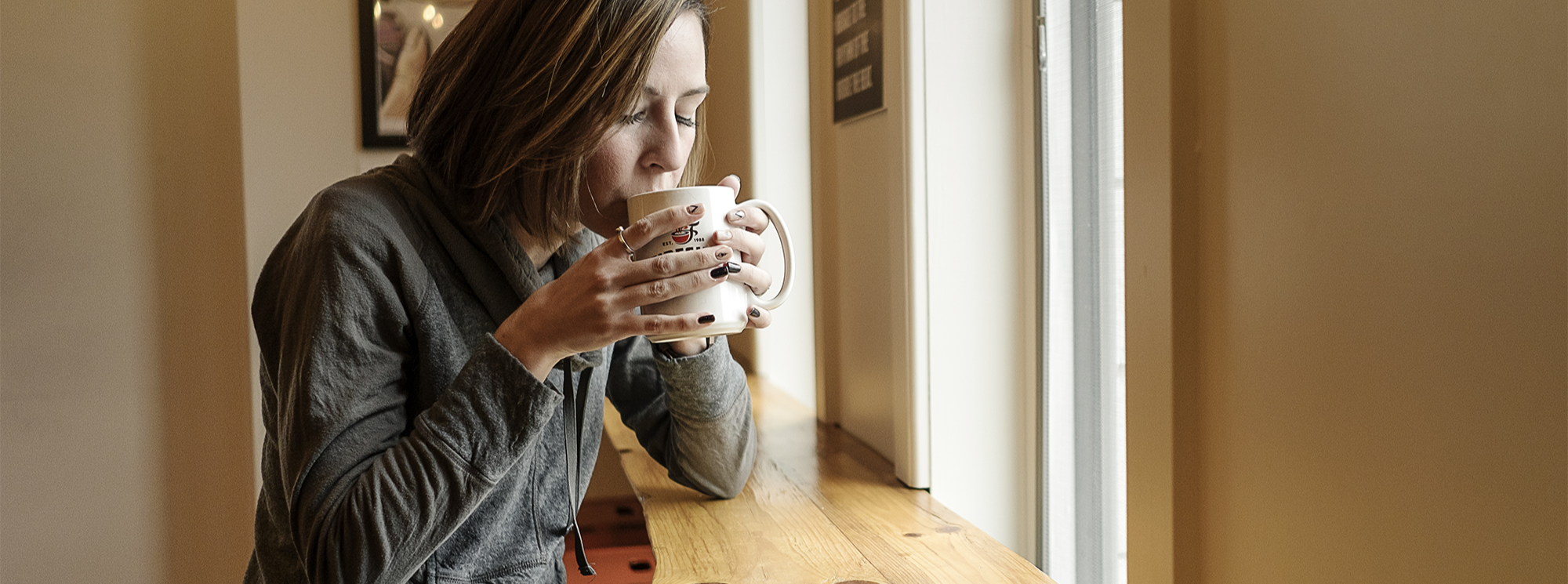 Woman sipping a mug of Fireside Coffee Cafe Mocha